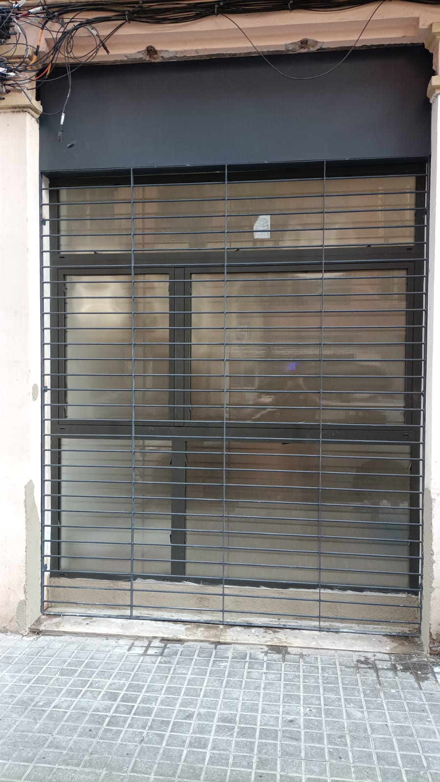 Reja de seguridad metálica en fachada de local comercial